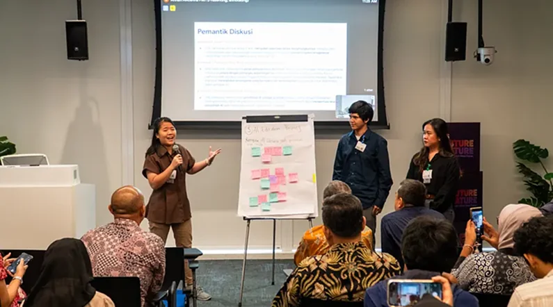 A student presenting the team’s work to the room