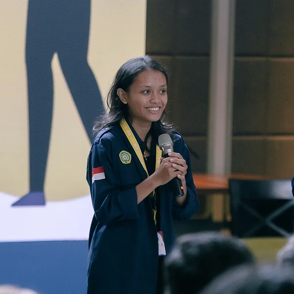 Bella speaking into a microphone at a gathering