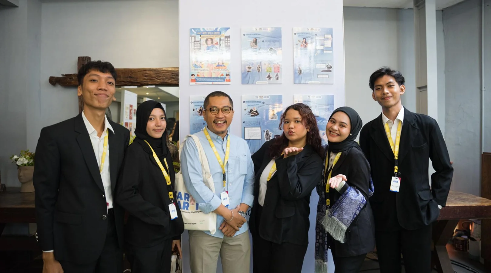 Penta Fantastica and their lecturer posing in front of their exhibition display