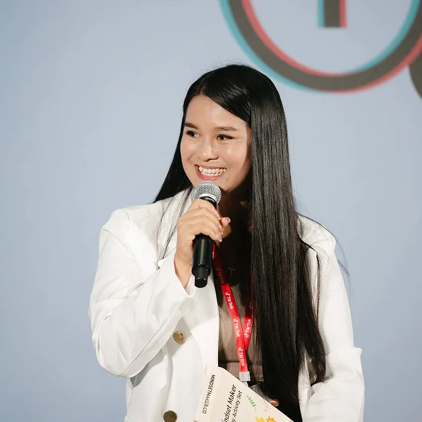 Kru Yui speaking into a microphone