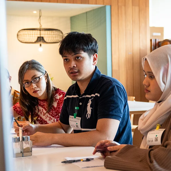 Students collaborating around a table at a workshop