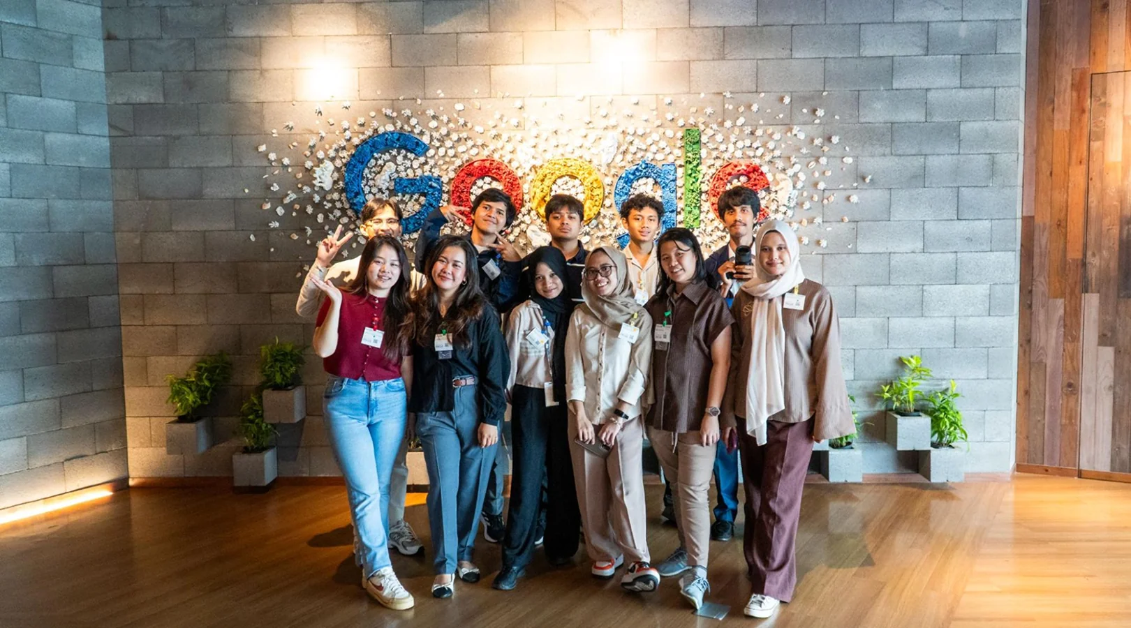 Muttaqin and fellow student ambassadors posing in front of the Google sign at the Google Office