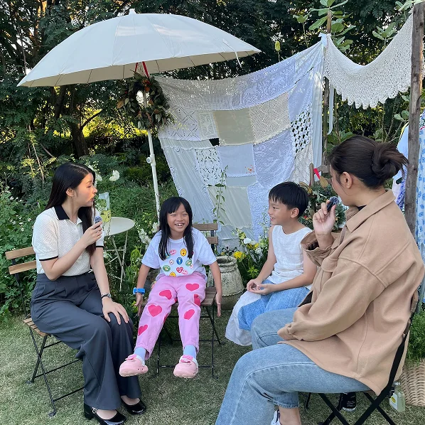 Adults and children sitting together in a garden