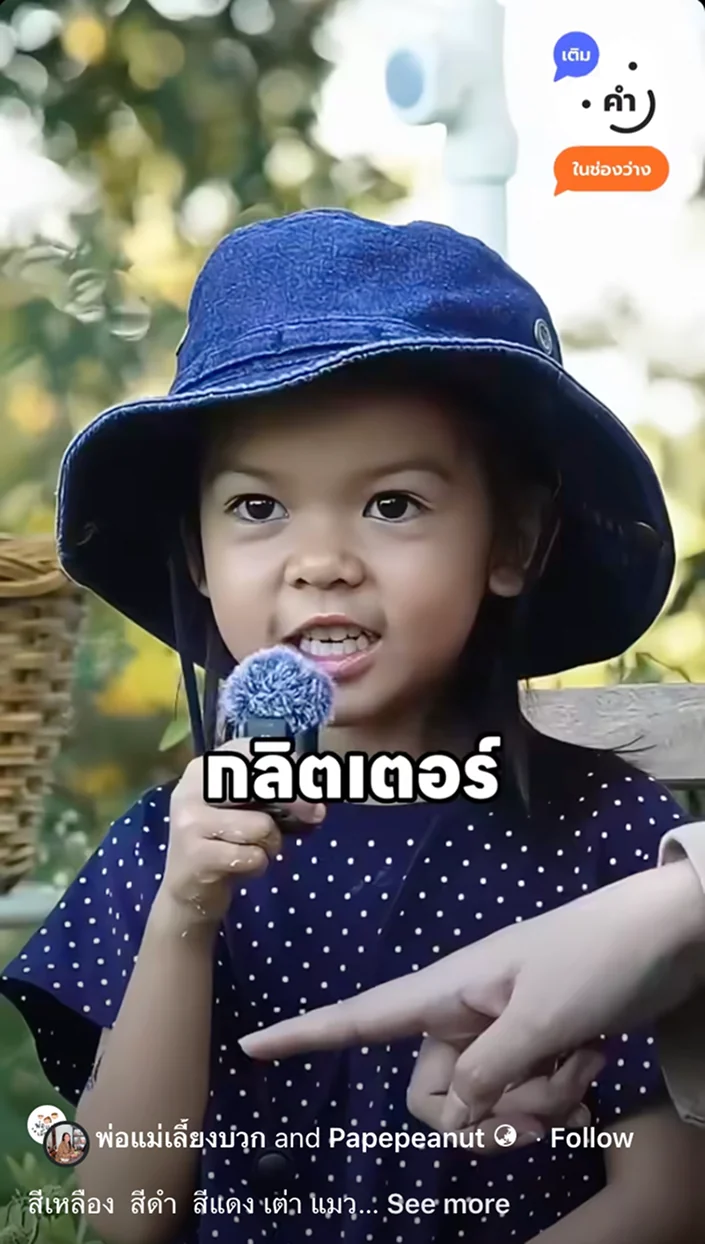 A kindergartener in a denim hat speaks into a microphone during a vox pop