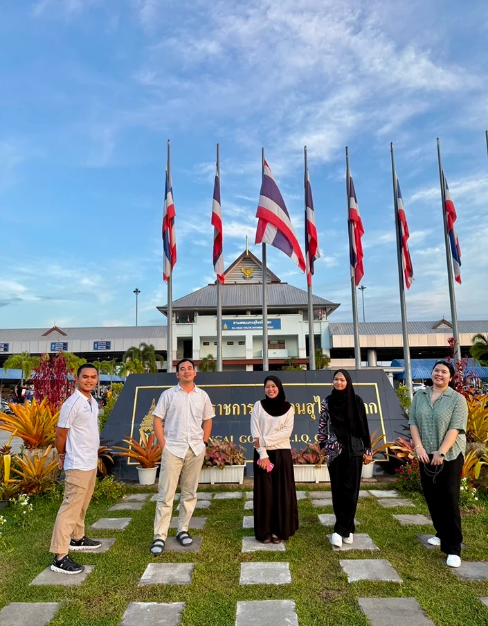 The author and the Luukrieang team standing before Thai flags at the Malaysia border