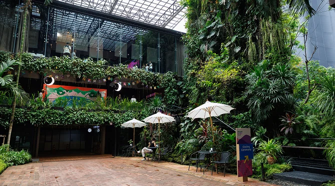 A leafy outdoor venue with umbrellas