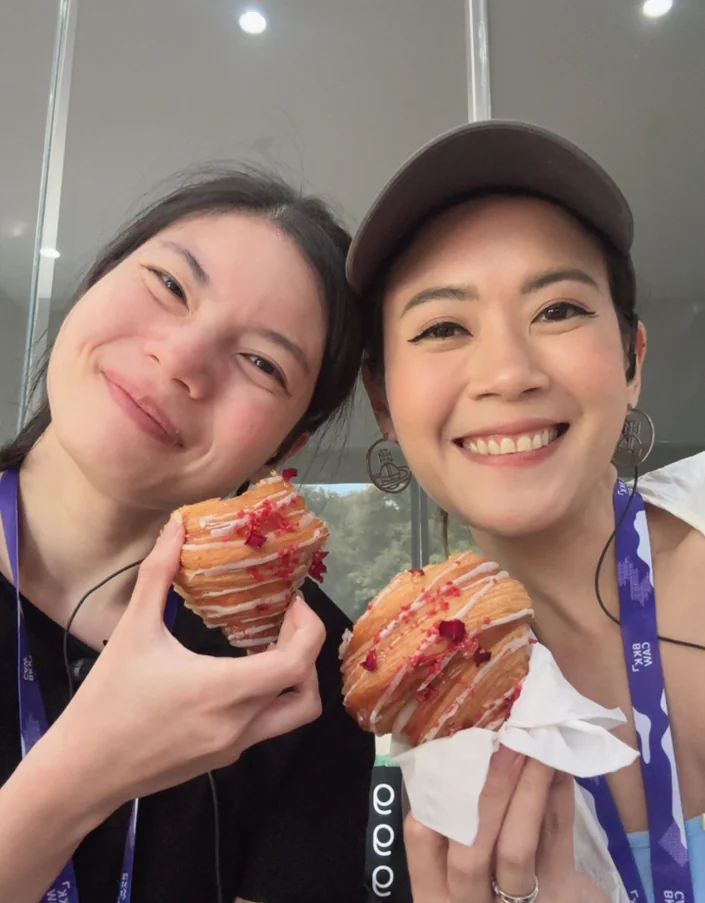 Toon and Tae taking a selfie together while holding pastries