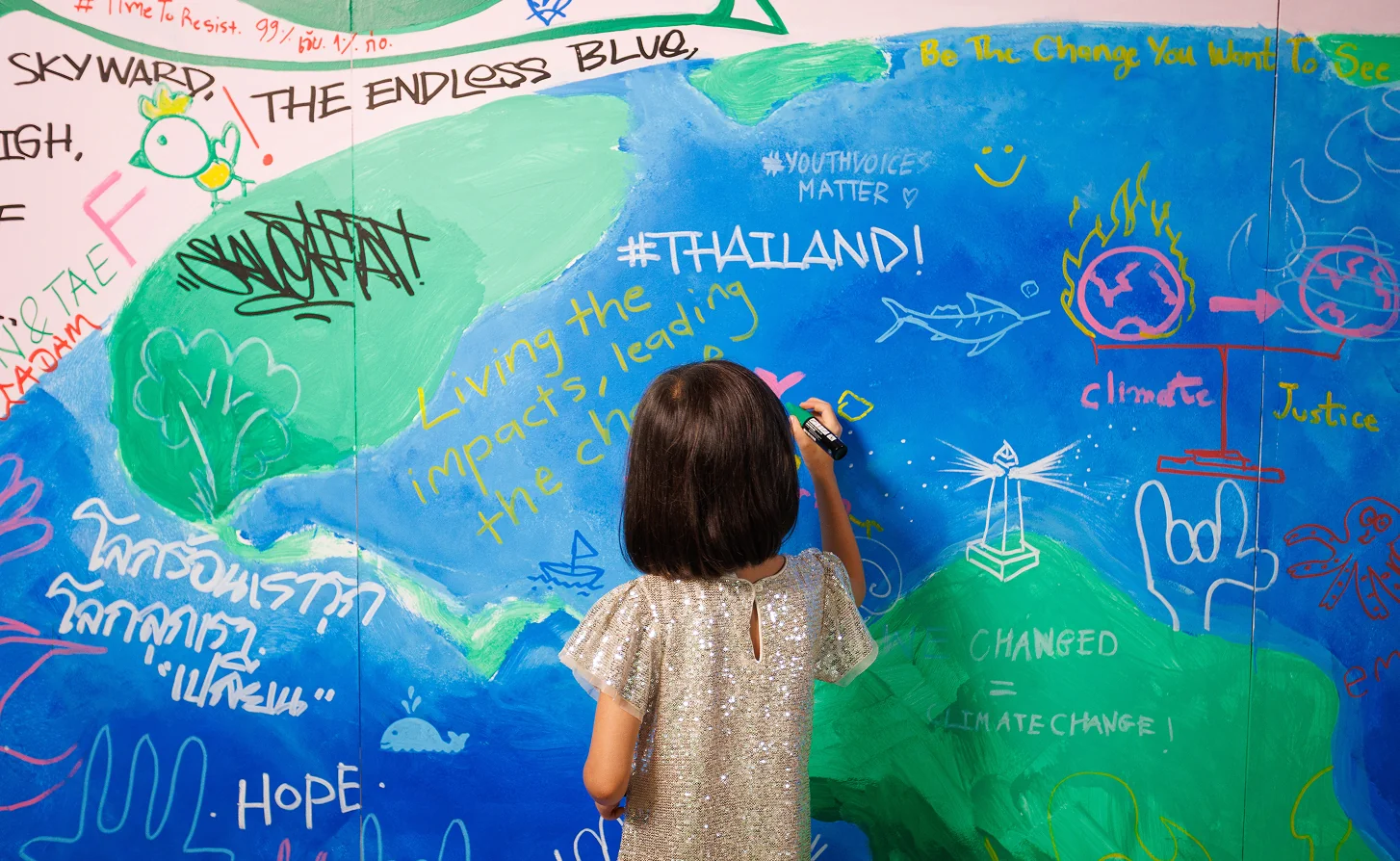 A child adding to the collaborative mural at the Closing Ceremony